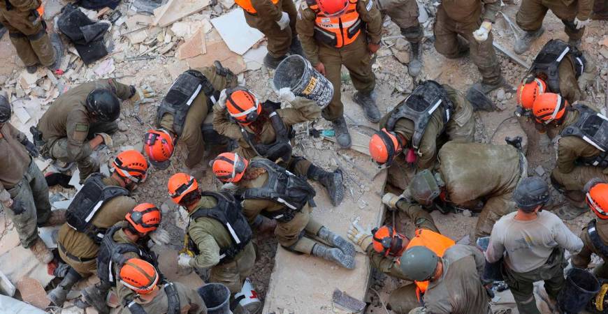 Israeli rescuers search through the rubble at the site of an overnight Iranian missile strike in Bat Yam on June 15, 2025. (Photo by GIL COHEN-MAGEN / AFP)