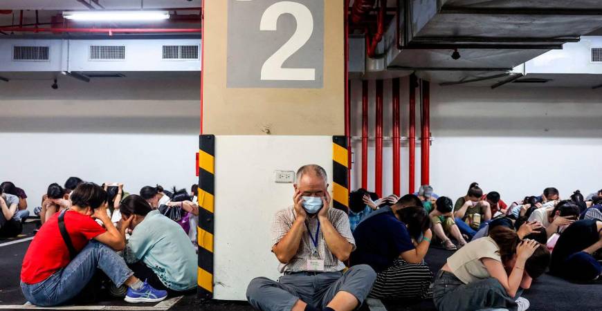 People take shelter during an air raid drill coinciding with the Kan Huang military exercises in Taipei on July 17, 2025. The annual civilian drill is being held in cities across Taiwan this week, alongside military training, to prepare the self-governed island for a potential Chinese invasion. - I-Hwa Cheng / AFP