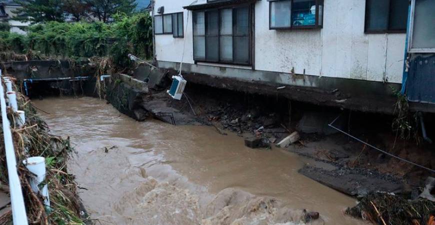 A house with a collapsed foundation is seen following heavy rains in Nikaho City, Akita prefecture on July 25, 2024. At least three people were missing in Japan on July 26, after heavy rains caused rivers to burst their banks, washing away cars and prompting several thousand locals to evacuate, authorities and media reports said. Local governments in the northern prefectures of Yamagata and Akita issued evacuation advisories to more than 200,000 people, the fire and disaster management agency said. - Japan OUT (Photo by JIJI PRESS / AFP)