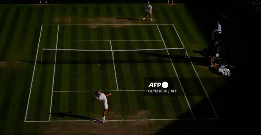 Spain's Carlos Alcaraz serves to Italy's Jannik Sinner during their men's singles final tennis match on the fourteenth day of the 2025 Wimbledon Championships at The All England Lawn Tennis and Croquet Club in Wimbledon, southwest London, on July 13, 2025. - Glyn KIRK / AFP