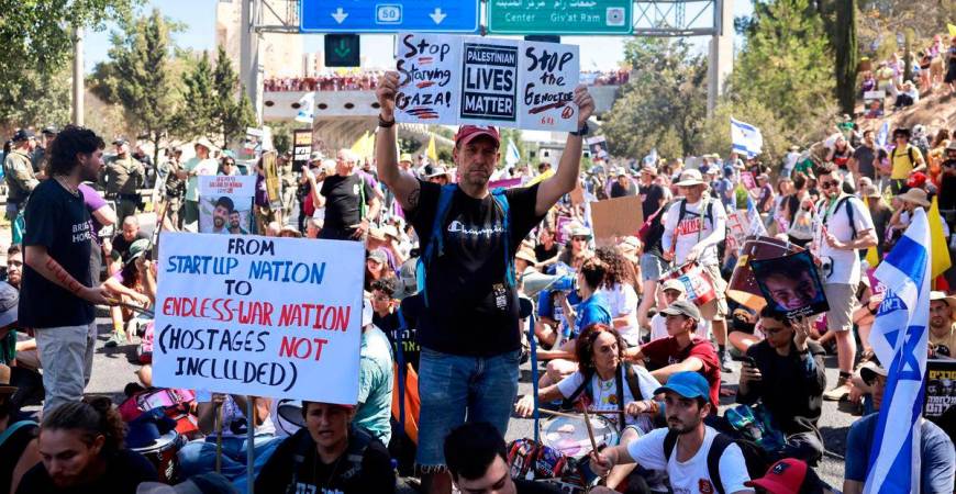 Families and supporters of Israelis held hostage by Hamas militants in Gaza since the October 7, 2023 attacks, hold placards and national flags during a protest calling for government action to secure their release in Jerusalem on August 17, 2025.(Photo by Menahem Kahana / AFP)
