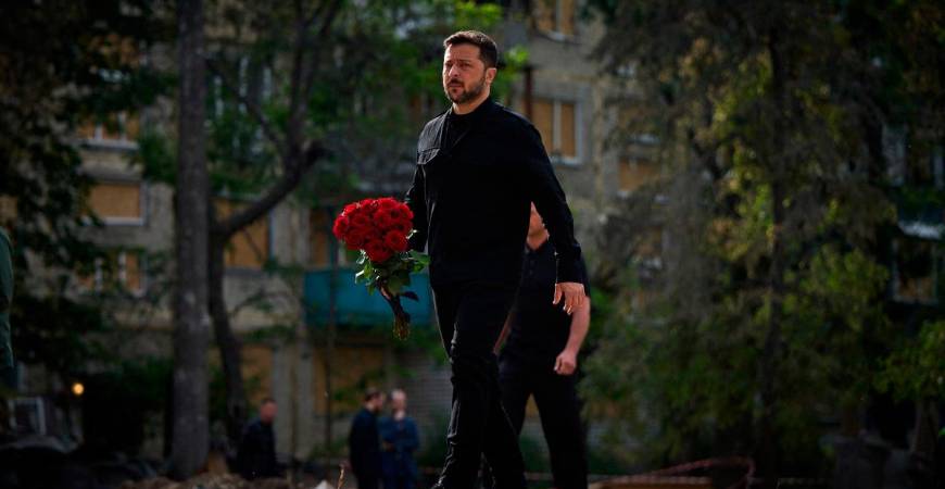 Ukraine’s President Volodymyr Zelensky arrives to lay a wreath of flowers to honour the memory of victims in front of a residential building in the Solomianskyi district of Kyiv on June 19, 2025, that was damaged following an attack on June 17, 2025. - AFP PHOTO / HANDOUT / UKRAINE PRESIDENCY