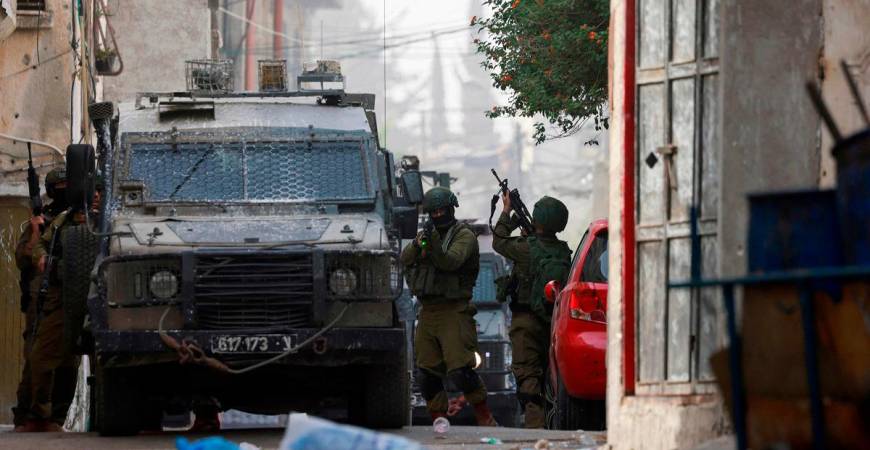 An Israeli soldier aims his weapon during a raid at the Balata refugee camp east of Nablus city in the occupied West Bank on August 11, 2025. - Jaafar ASHTIYEH / AFP