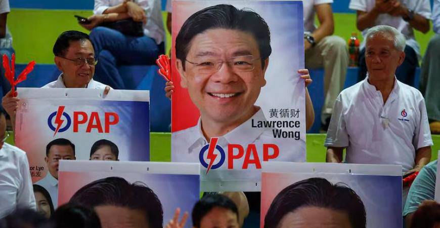 People’s Action Party supporters hold signs in support of Singapore’s Prime Minister Lawrence Wong, as they gather at an assembly area to wait for results of the general election in Singapore - REUTERSpix