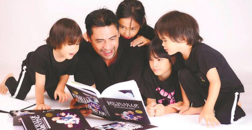Sheikh Muszaphar reading his new book with his family. –Courtesy of Datuk Dr Sheikh Muszaphar Shukor