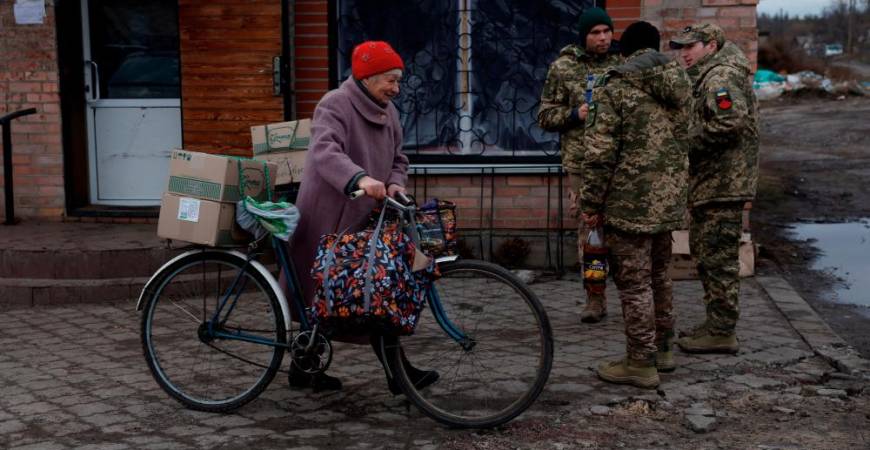 A woman walks with her bicycle carrying boxes of humanitarian aid provided by the Ukrainian military as Russia's attack on Ukraine continues, in Yampil, Ukraine, December 28, 2022. REUTERSPIX