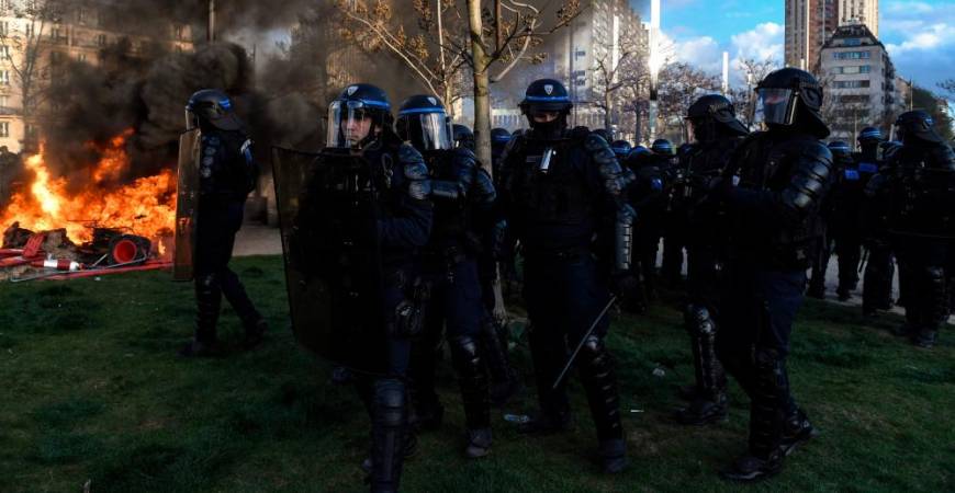 French riot police officers walk past as fire during a demonstration at Place d’Italie on the 11th day of action after the government pushed a pensions reform through parliament without a vote, using the article 49.3 of the constitution, in Paris on April 6, 2023. AFPPIX