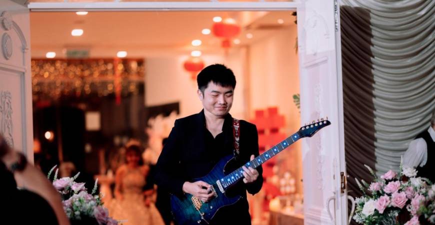 Eugene clearly enjoys performing at weddings, which can be seen in his smile.