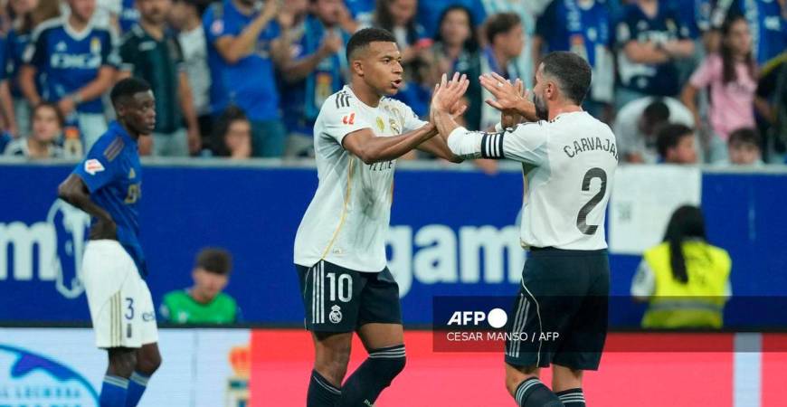 Real Madrid's French forward #10 Kylian Mbappe celebrates scoring his team's first goal with Real Madrid's Spanish defender #02 Dani Carvajal during the Spanish league football match between Real Oviedo and Real Madrid CF at Carlos Tartiere Stadium in Oviedo on August 24, 2025. - AFP