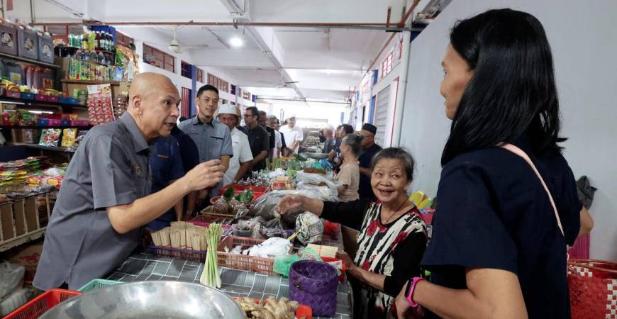 Menteri Perdagangan Dalam Negeri dan Kos Sara Hidup, Datuk Armizan Ali, berinteraksi mesra dengan peniaga di Pasar Am Papar ketika melakukan walkabout di Pekan Papar, hari ini. - fotoBERNAMA