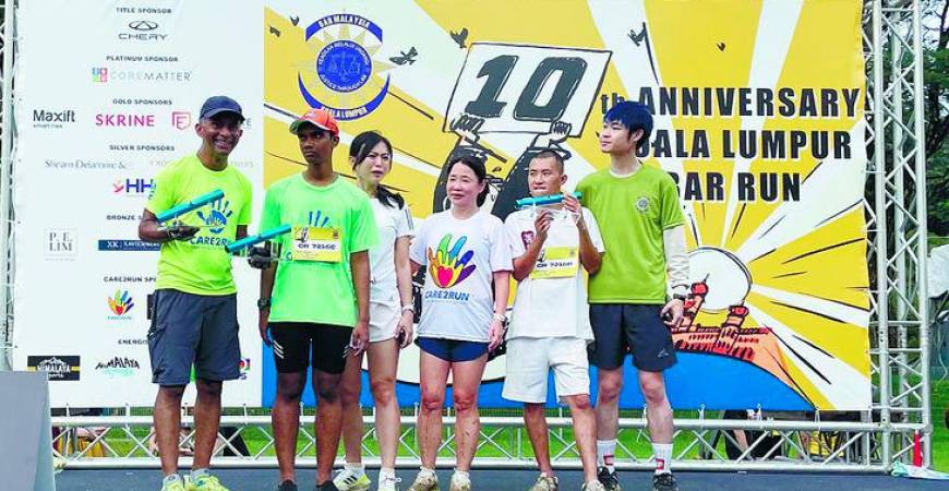 (left) Prem handing out prizes won by SN adults in the presence of Tan Lay Geok (fourth left), one of the founders of Care2Run and a lawyer by profession, with volunteer participants.