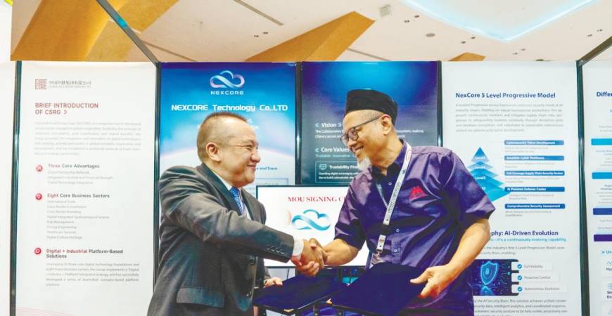 Nexcore Technology CEO Tang Yang (left) and Abdul Wahab exchanging documents after the signing ceremony.