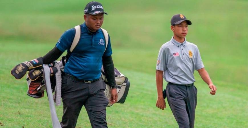 Muhammad Afham Othman (right) and his caddie during practice.