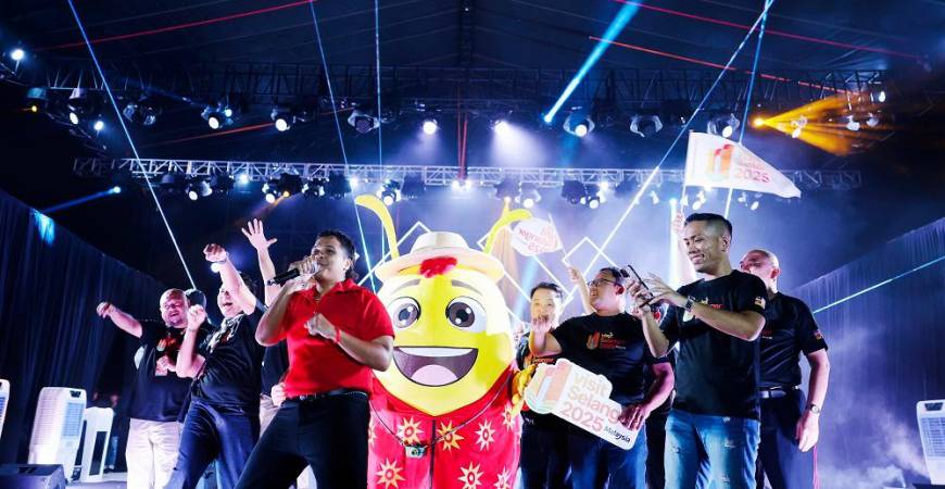 Aizat (in red) performing the official theme song, together with VSY 2025 mascot Spark the Firefly and other VIPs.