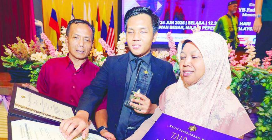 The best student in the blind category, Nik Muhammad Ahnaf Rujhiee Raja Anuar, shares joy with his parents during the award ceremony for the best students in STPM, MUET and SKBMW 2024 at the Malaysian Examinations Council complex in Kuala Lumpur yesterday. – Adib Rahwi Yahya/theSun