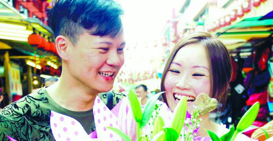 A woman giving a bouquet of flowers to her boyfriend in conjunction with Boyfriend Day. – Syed Azahar Syed Osman/theSun