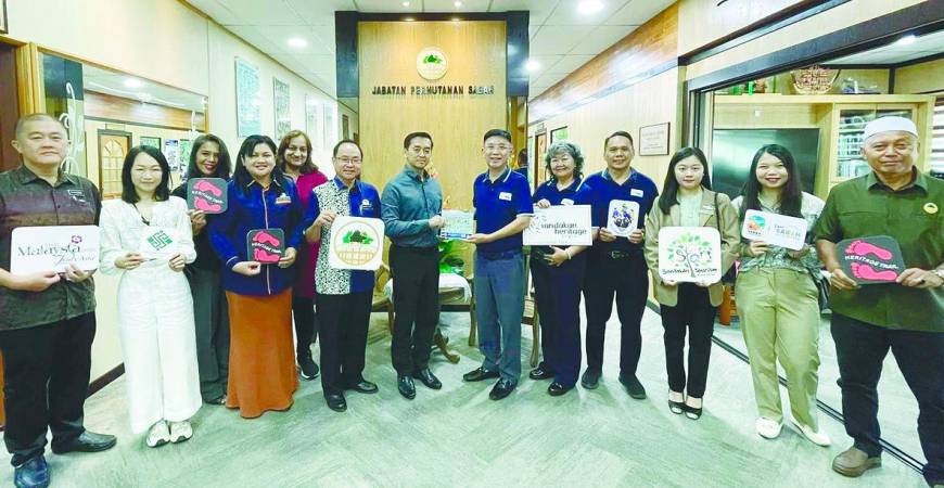 Lai (sixth from right) presents a memento to Kugan during the courtesy call.