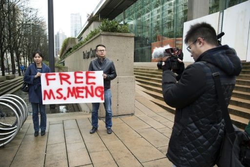 Ada Yu of Vancouver (L) and a man who wished to remain unnamed, hold a sign calling for the release of Huawei Technologies Chief Financial Officer Meng Wanzhou outside her bail hearing. — AFP