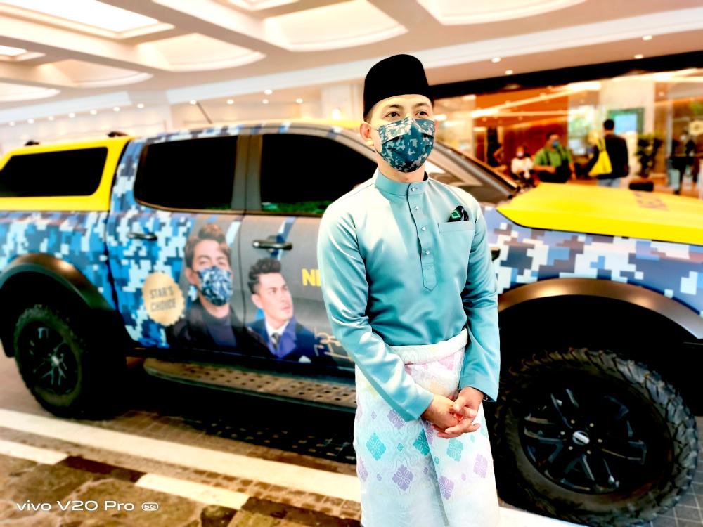 Izzue Islam, Ambassador of Neutrovis Barrack Series posing next to the Neutrovis car.