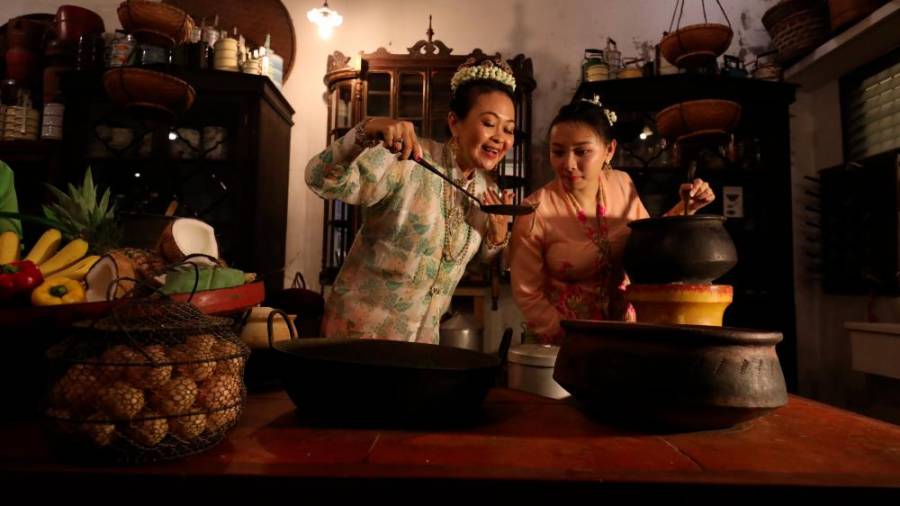 Lilian Tong and Cheng Hooi Yen whipping up traditional nyonya dishes.