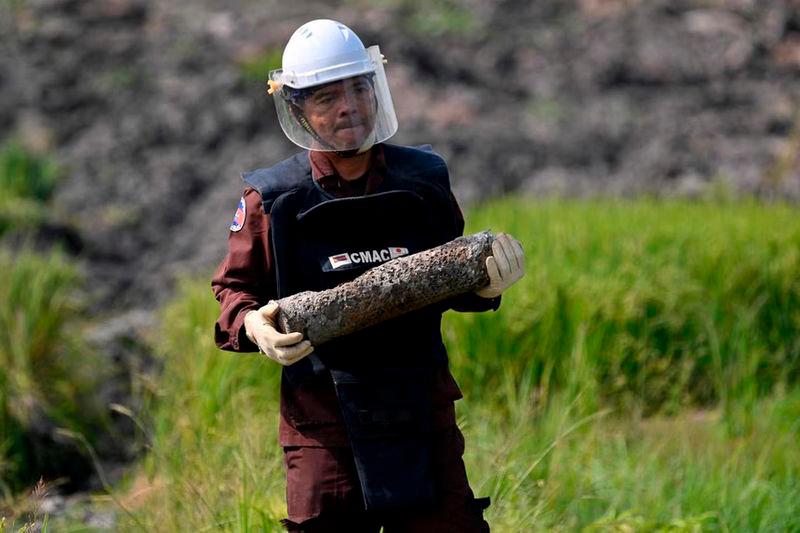 A deminer from the Cambodian Mine Action Centre carrying an unexploded ordnance in Svay Rieng province - AFPpix