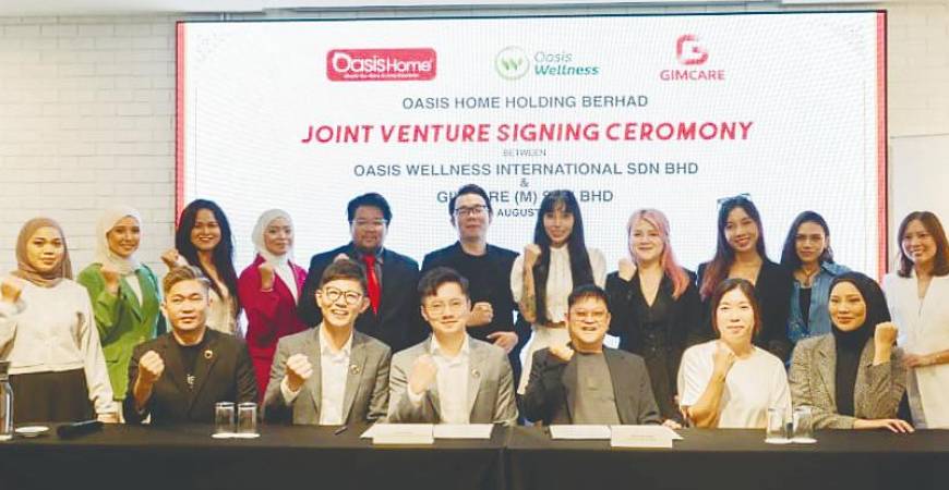 Teoh (seated, second from left) at the signing of the joint venture agreement between Oasis Wellness International and GIMCare (M).
