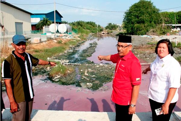 Dr Abdul Aziz Bari (C) pointing towards the polluted Kampung Baru Sungai Tiang Rungkup tributary. — Bernama