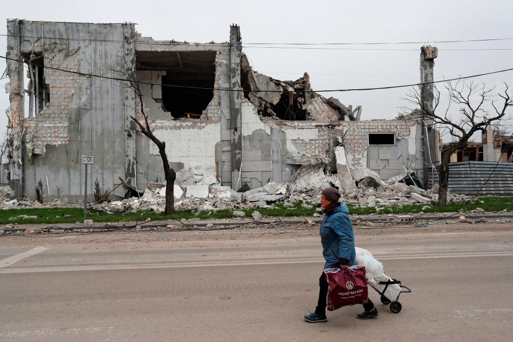 A local resident walks past a building destroyed during Ukraine-Russia conflict in the southern port city of Mariupol, Ukraine. - REUTERSpix