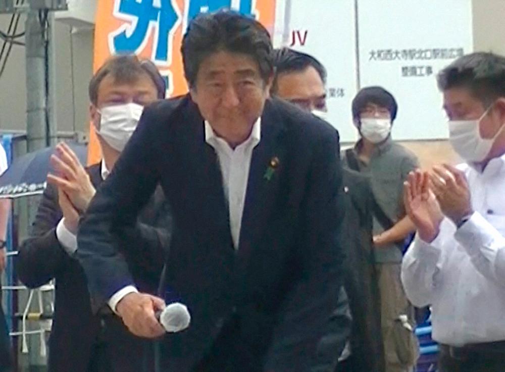 A screen grab shows a man believed to be Tetsuya Yamagami, the suspect of shooting former Japanese Prime Minister Shinzo Abe, behind Abe who is about to make a speech in Nara, western Japan July 8, 2022/REUTERSPix