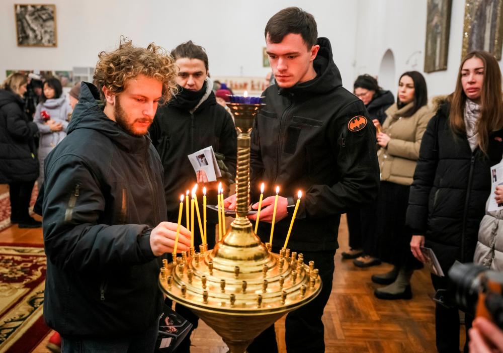 Volunteers light candles after a memorial service for Andrew Bagshaw, one of the two British volunteers killed in eastern Ukraine while attempting a rescue from Soledar, amid Russia's attack on Ukraine, in Kyiv, Ukraine January 29, 2023. REUTERSpix