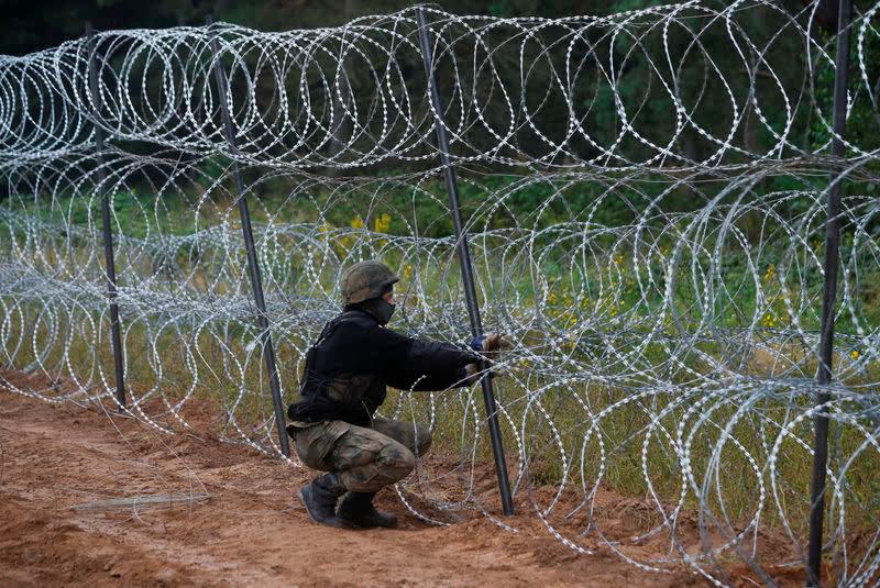 Polish soldiers build a fence on the border between Poland and Belarus near the village of Nomiki. — AFP
