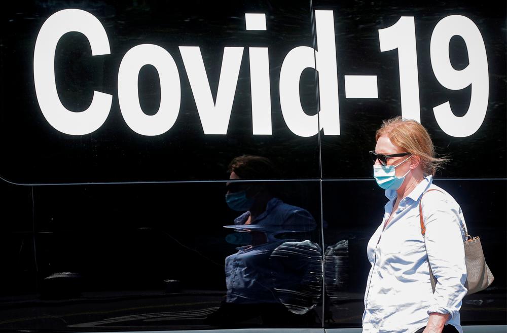 FILE PHOTO: A woman wearing a mask passes by a coronavirus disease mobile testing van, as cases of the infectious Delta variant of Covid-19 continue to rise, in Washington Square Park in New York City, U.S., July 22, 2021. -Reuters