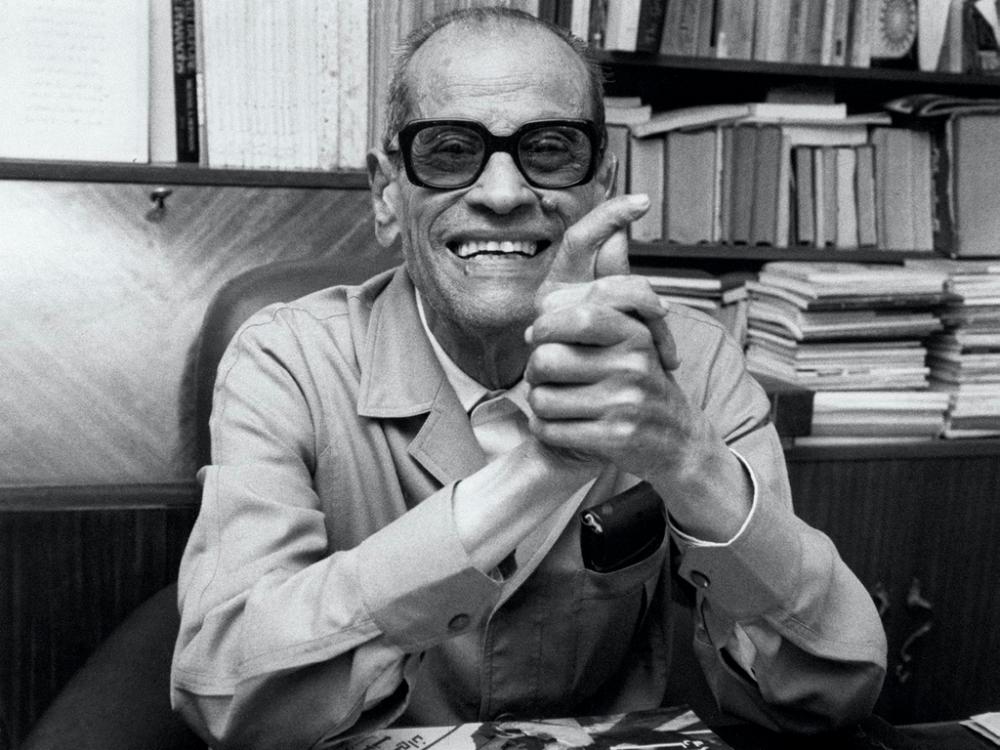 Naguib Mahfouz by his desk in Cairo in 1988, obviously happy about his Nobel Prize for Literature — AFP