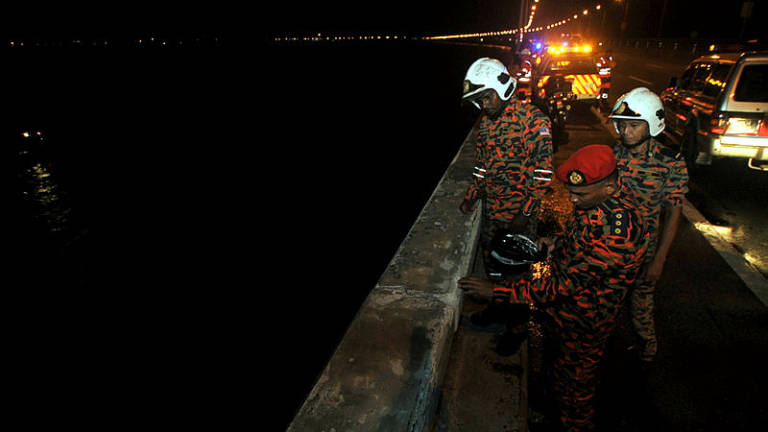 Fire and Rescue Department officers at the scene of the accident at the Penang Bridge on Jan 19.