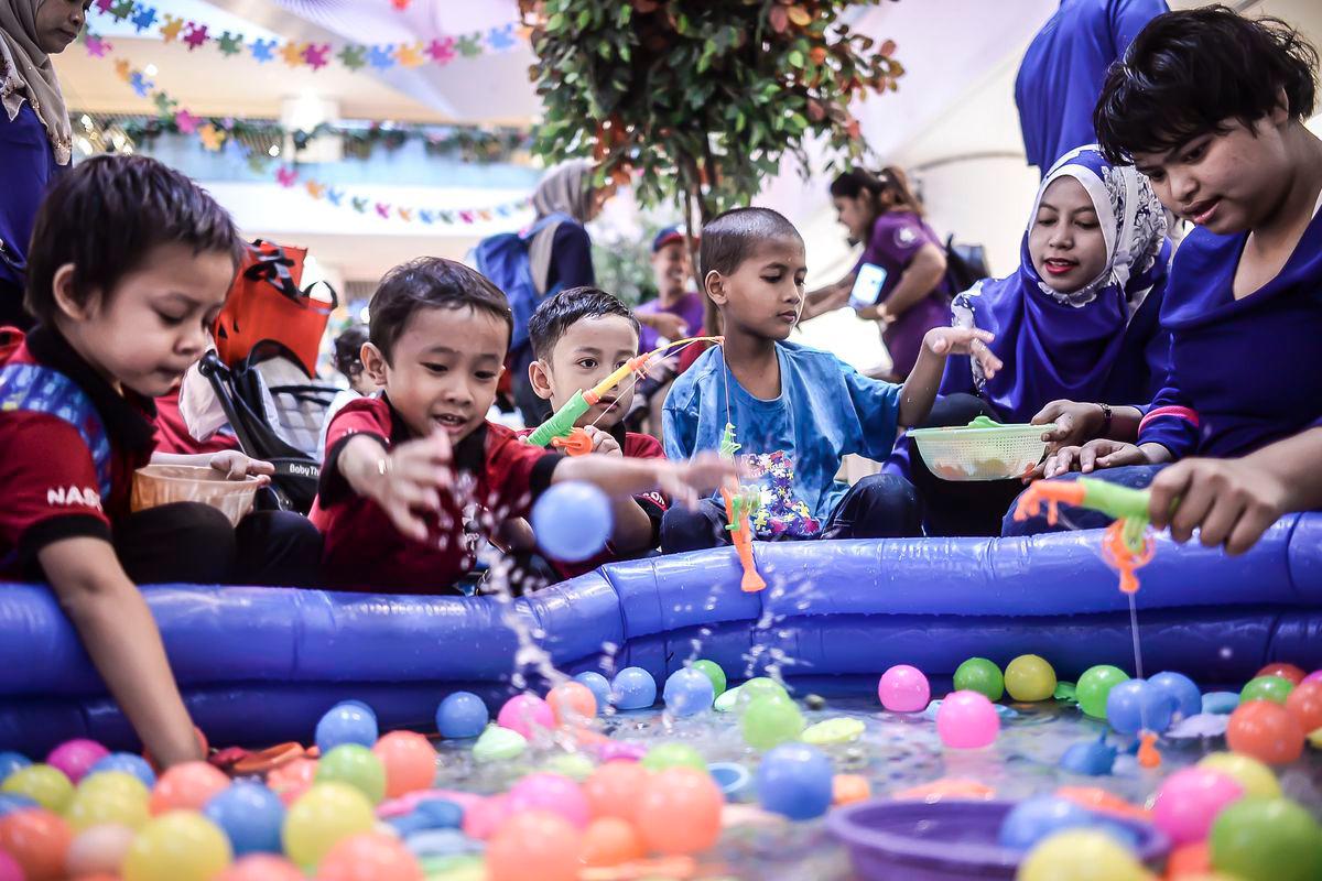 Kids from The National Autism Society of Malaysia (NASOM) playing while looking by parent during World Austism Day at Sunway Putra Mall. - Adib Rawi Yahya / theSun