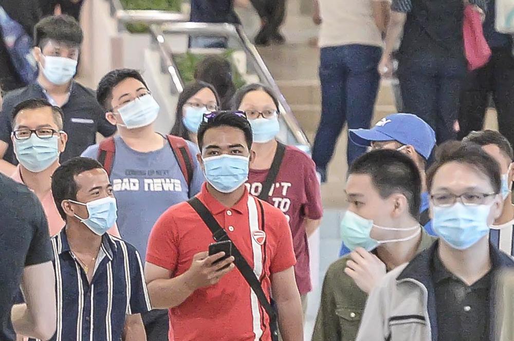 People wear protective masks as they walk in the mall in Kuala Lumpur on June 08, 2020.