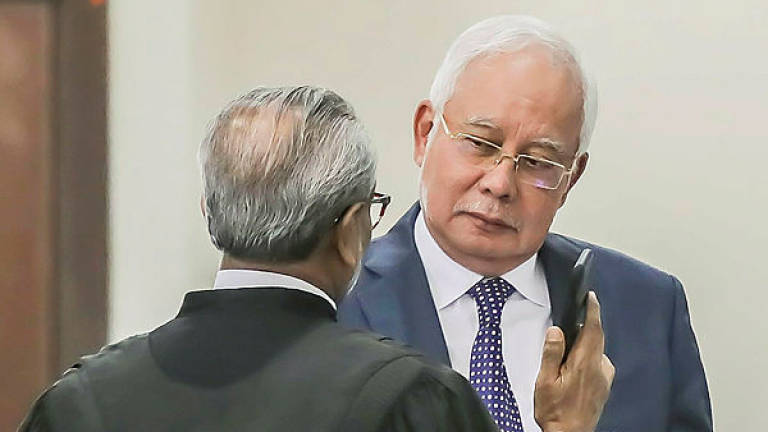 Former prime minister Datuk Seri Najib Abdul Razak and his lawyer Tan Sri Muhammad Shafee Abdullah at the trial of the SRC International case in the Kuala Lumpur Courts Complex. — Sunpix by Adib Rawi Yahya