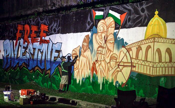 $!WORLDLY MESSAGE ... Artist Muhammad Fakhrul Akmal Shamsurrijal completing a mural in Bangi, Selangor that highlights the situation in Palestine. – ADIB RAWI YAHYA /THESUN