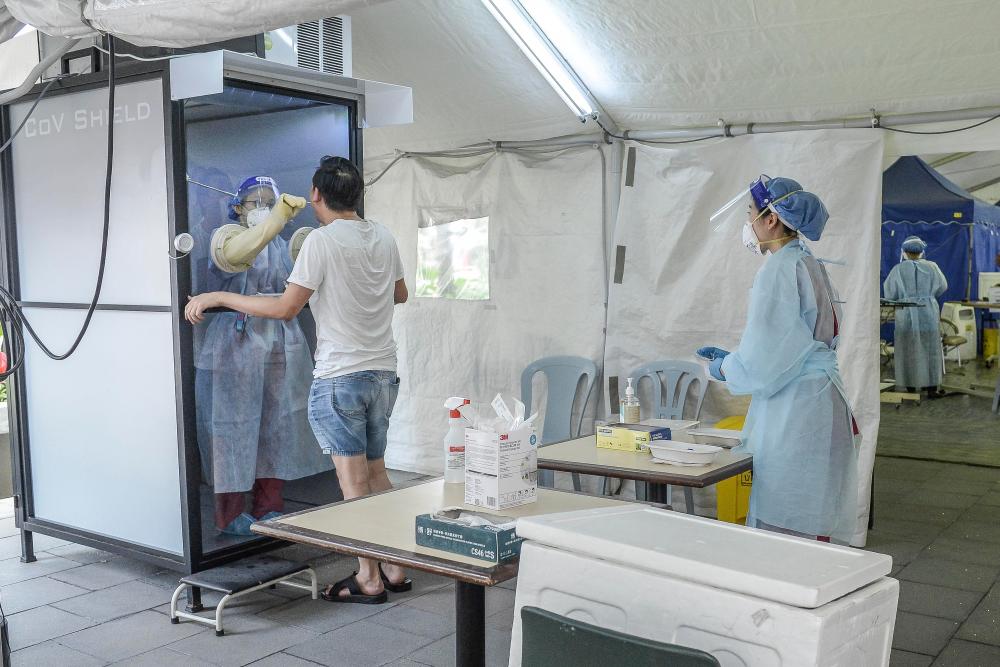 A doctor collects samples for a coronavirus test from behind a shield at private Sunway Medical Centre in Sunway, outside of Kuala Lumpur. (Pix for representational purpose only) -Adib Rawi Yahya/THESUNPix
