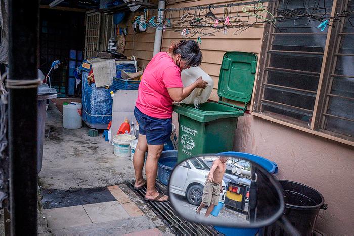$!Affected resident pouring water into the storage due to the water shortages after Air Selangor shut down four water treatment plants due to pollution, just a day after a burst pipe affected supply to some of the residents. – ADIB RAWI YAHYA/THESUN