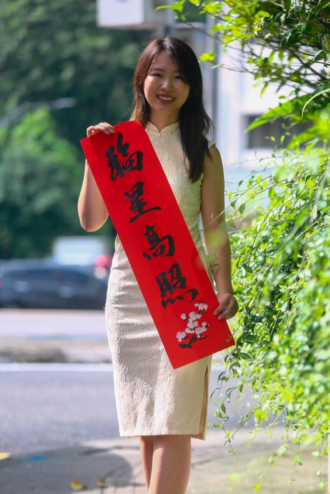 Sim Li Wei with her calligraphy painting– PIC BY ADAM AMIR HAMZAH/THESUN