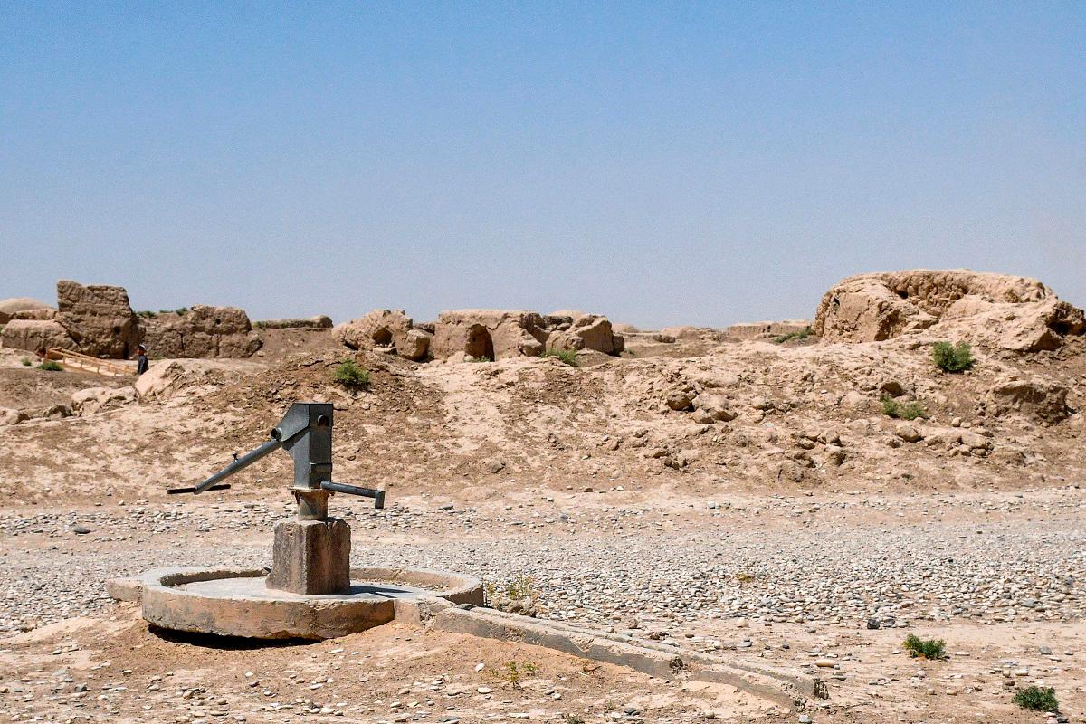 This photograph taken on July 10, 2025 shows a hand pump near dilapidated dome-shaped traditional Afghan houses on a deserted street as chronic water scarcity stalks the drought-ridden village of Bolak in the Chahar Bolak district at Balkh province. - Atif Aryan / AFP