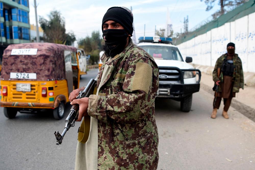 Taliban fighters stand gguard along a roadside in Jalalabad on December 12, 2021. AFPpix