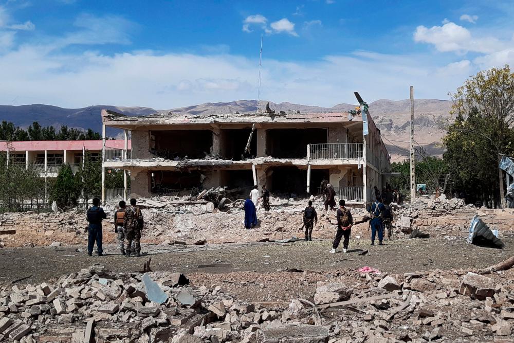 Afghan security personnel inspect the site of a car bomb blast near the destroyed office building of Afghanistan's intelligence agency in the city of Aybak on July 13, 2020. — AFP
