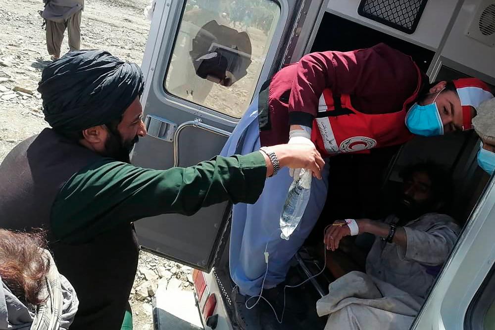 This photograph taken on June 22, 2022 and received as a courtesy of the Afghan government-run Bakhtar News Agency shows a member of the Afghan Red Crescent Society giving medical treatment to a victim following an earthquake in Afghanistan’s Gayan district, Paktika province. AFPPIX