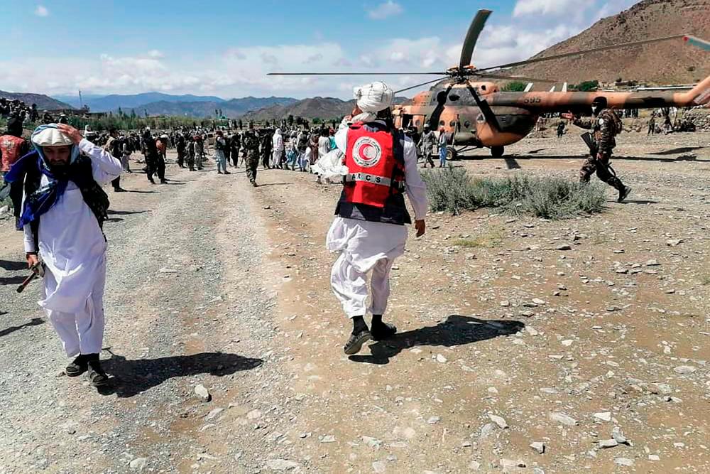 This photograph taken on June 22, 2022 and received as a courtesy of the Afghan government-run Bakhtar News Agency shows soldiers and Afghan Red Crescent Society officials near a helicopter at an earthquake hit area in Afghanistan’s Gayan district, Paktika province. AFPPIX