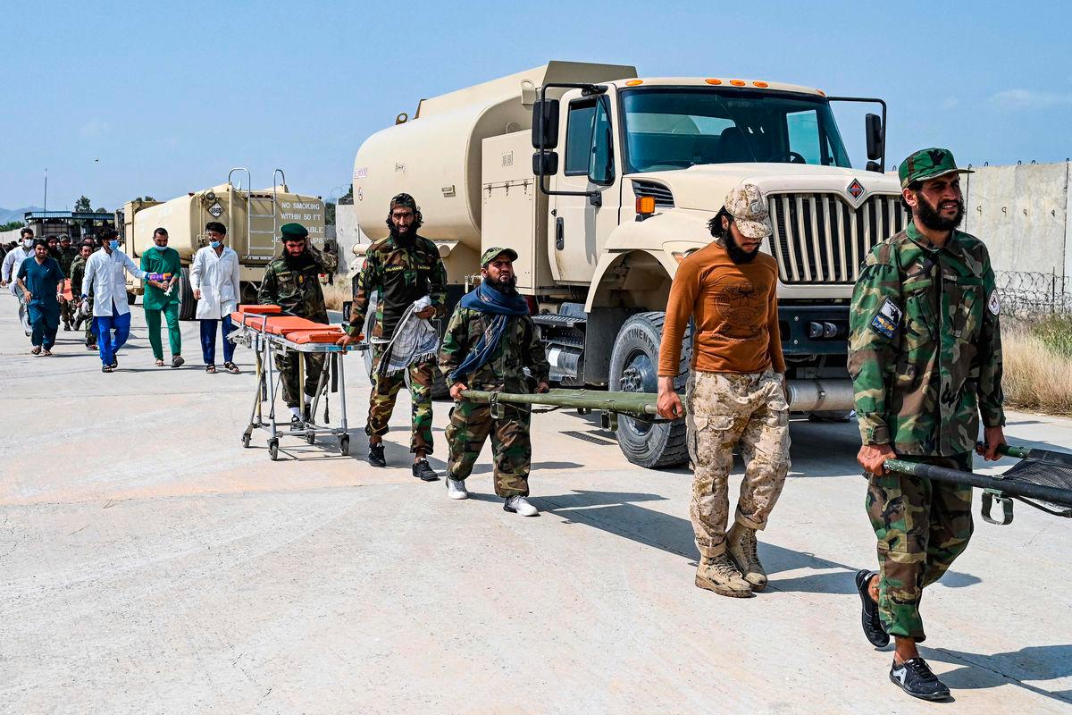 Afghan medical and Taliban security personnel carry stretchers for evacuated earthquake victims upon their arrival for medical assistance in Jalalabad on September 1, 2025. (Photo by Wakil KOHSAR / AFP)