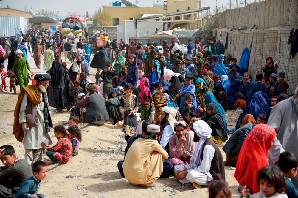 In this photo taken on November 1, 2023, Afghan refugees wait near a registration centre upon their arrival from Pakistan, at the Afghanistan-Pakistan border in the Spin Boldak district of Kandahar province. More than 165,000 Afghans have fled Pakistan in the month since its government ordered 1.7 million people to leave or face arrest and deportation, officials said on November 2/AFPPix