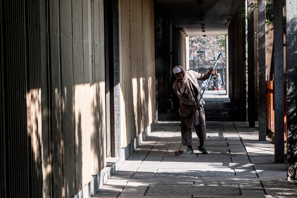A worker cleans the corridor of Esteqlal High School in Kabul on March 21, 2023. AFPPIX
