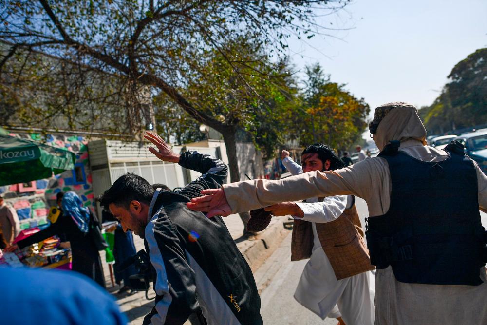 Taliban members (R) attack journalists covering a women’s rights protest in Kabul on October 21, 2021. The Taliban violently cracked down on media coverage of a women’s rights protest in Kabul on October 21 morning, beating several journalists. AFPpix